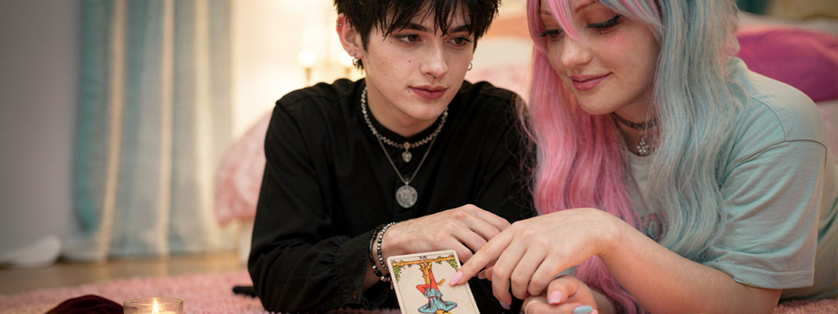 Pareja joven consultando una carta del tarot invertida juntos, ambiente íntimo con velas