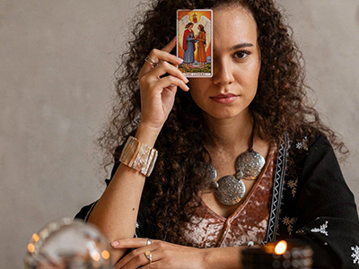 Mujer sosteniendo la carta de los enamorados del tarot